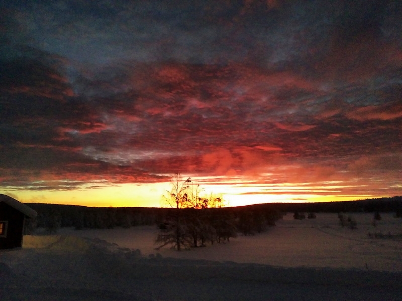 Sonnenuntergang mit rotem Himmel und Wolken. Schneelandschaft.